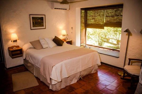 Un dormitorio con una cama grande y una ventana en Estancia La Paz casa de campo, en Paysandú