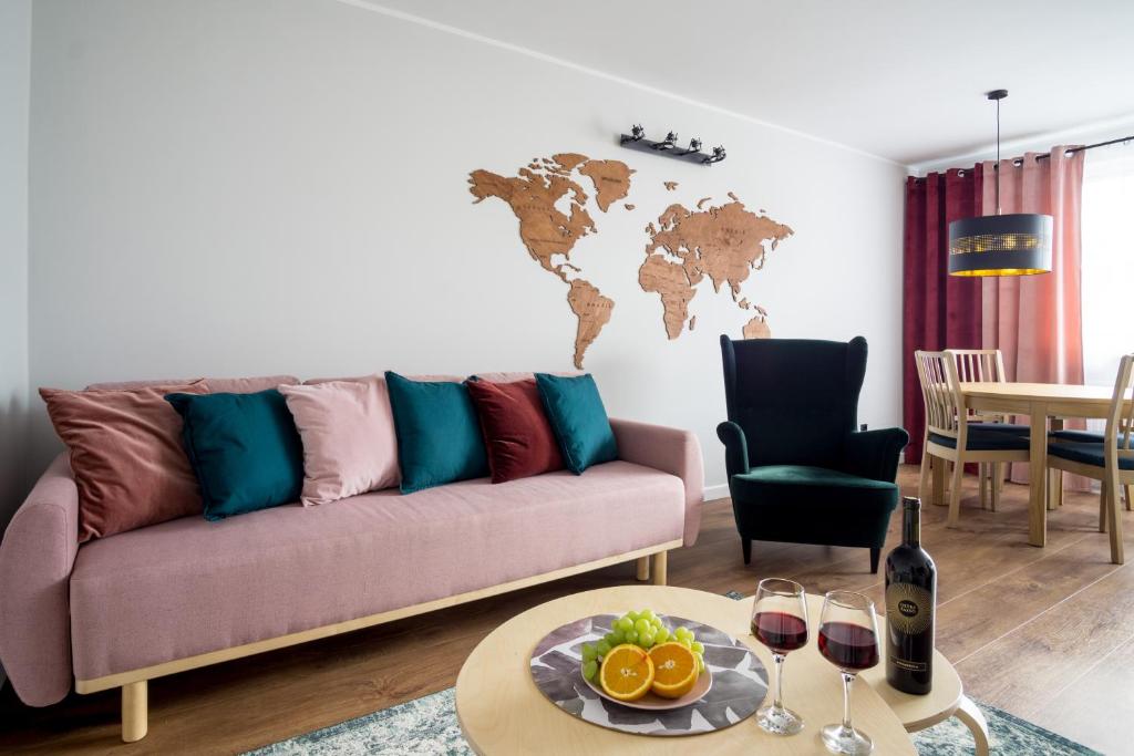 uma sala de estar com um sofá e uma mesa com copos de vinho em Song`s Apartment em Sopot