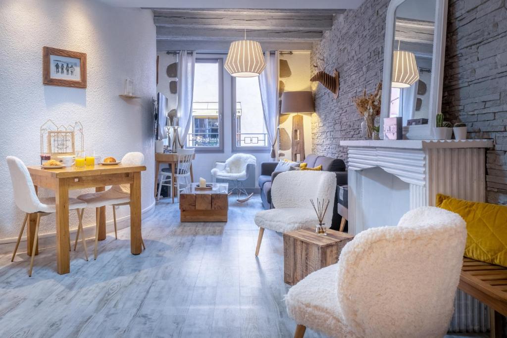 uma sala de estar com mesa e cadeiras em Un Cottage Alpin chaleureux dans le coeur d Annecy avec 2 vélos em Annecy