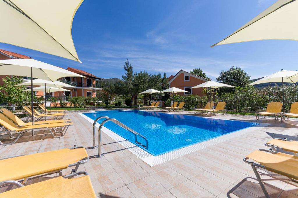 a pool with chairs and umbrellas at a resort at Peristera in Katelios