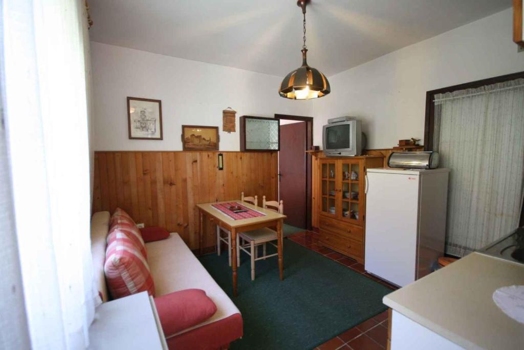 salon z kanapą, stołem i lodówką w obiekcie One-Bedroom Apartment in Malinska VIII w mieście Malinska