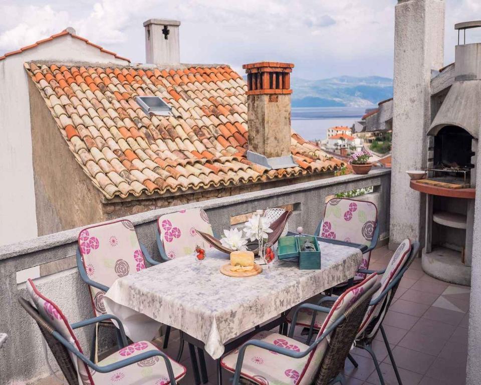 a table and chairs on a balcony with a view at Apartment in Vrbnik/Insel Krk 14527 in Vrbnik