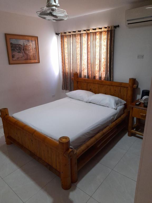 uma cama num quarto com uma estrutura em madeira em Hotel Cartagena Airport em Cartagena de Indias