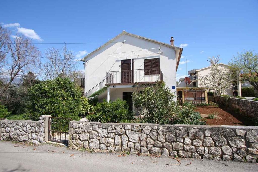 a white house with a stone wall in front of it at Apartment in Silo/Insel Krk 14533 in Šilo