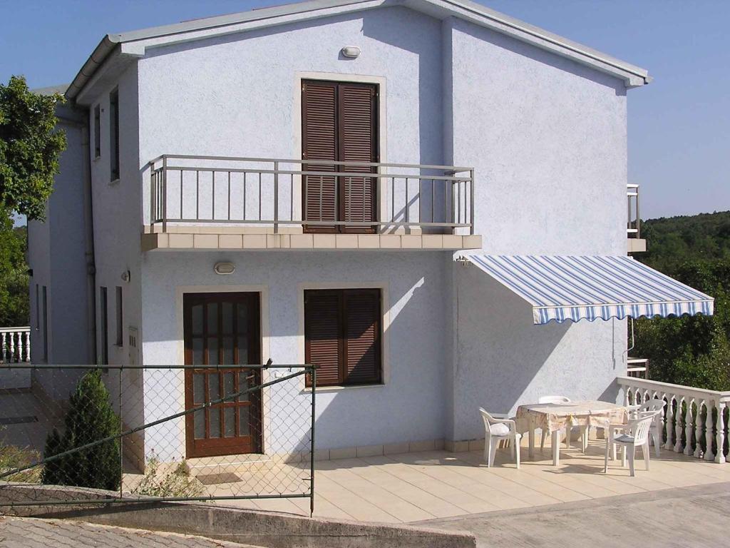 a white house with a table and a balcony at Apartment in Silo/Insel Krk 13498 in Šilo