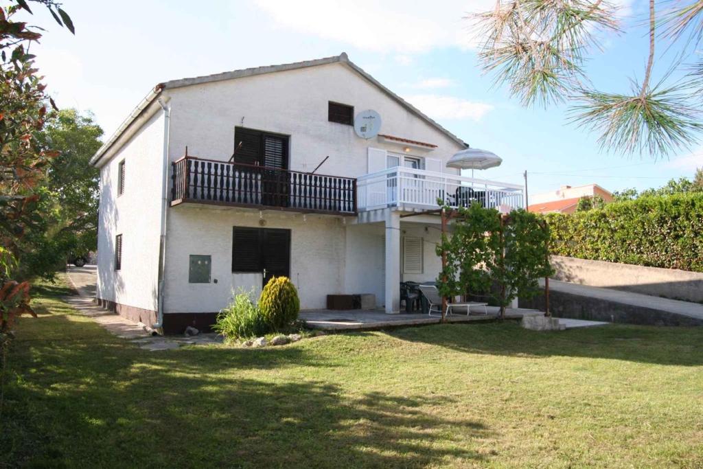a white house with a balcony and a yard at Apartment in Silo/Insel Krk 14597 in Šilo