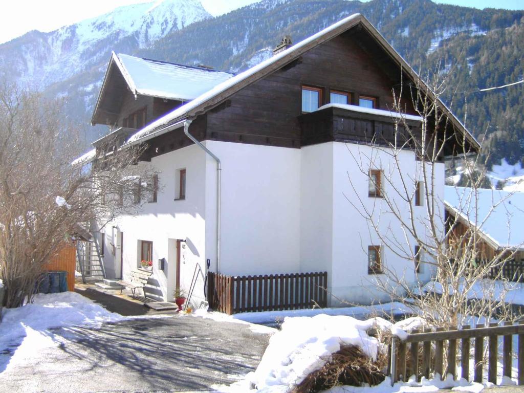 a house in the snow with mountains in the background at Apartment Jerzens 1 in Jerzens