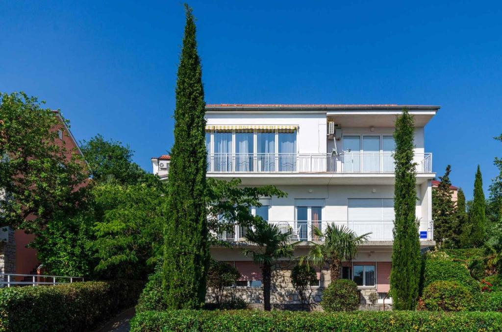 a white building with trees in front of it at Apartment in Crikvenica 5215 in Dramalj