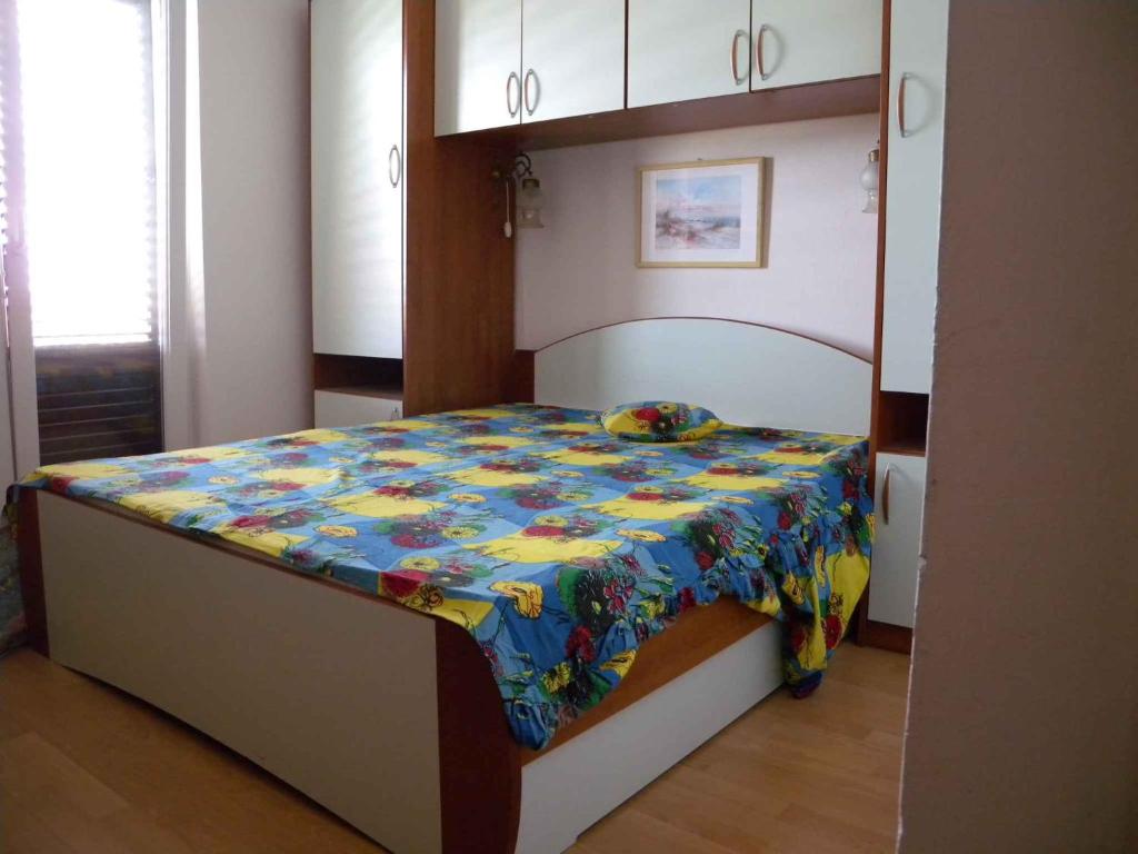 una camera da letto con un letto con una trapunta colorata di Apartment Supetarska Draga 5 a Supetarska Draga