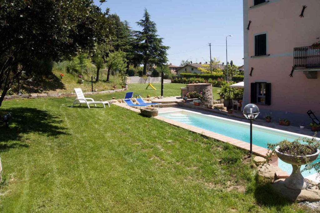 een tuin met een zwembad en een huis bij Apartment Umbertide 2 in Niccone