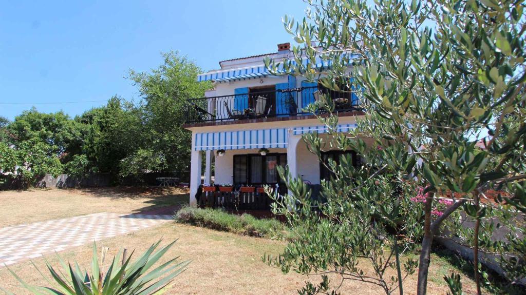 a blue and white house with a balcony at Apartments in Malinska/Insel Krk 14421 in Sveti Anton