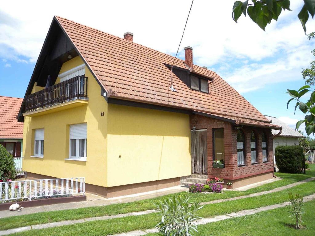 una casa amarilla con techo marrón en Apartment Balatonbereny 4, en Balatonberény