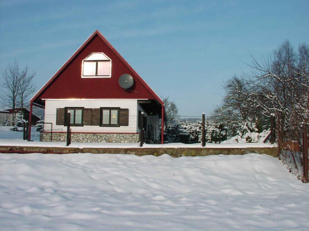 VlciceにあるHoliday home in Vlcice u Trutnova 2323の雪の赤い屋根の家