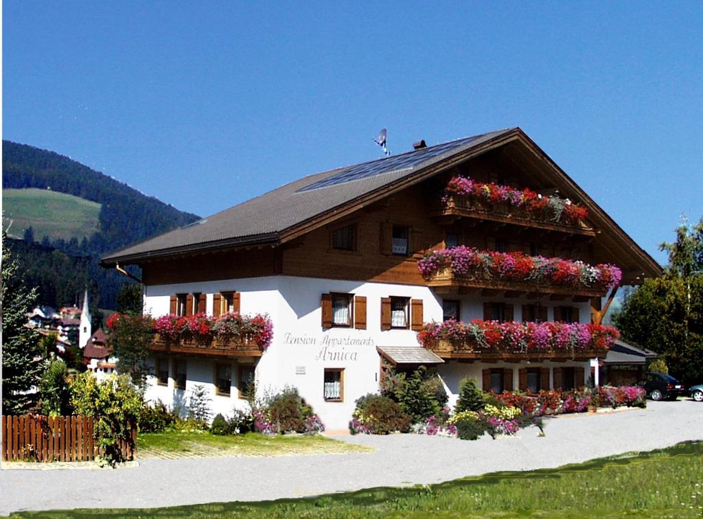 a house with flower boxes on the side of it at Pension Arnica B&B in San Vigilio Di Marebbe