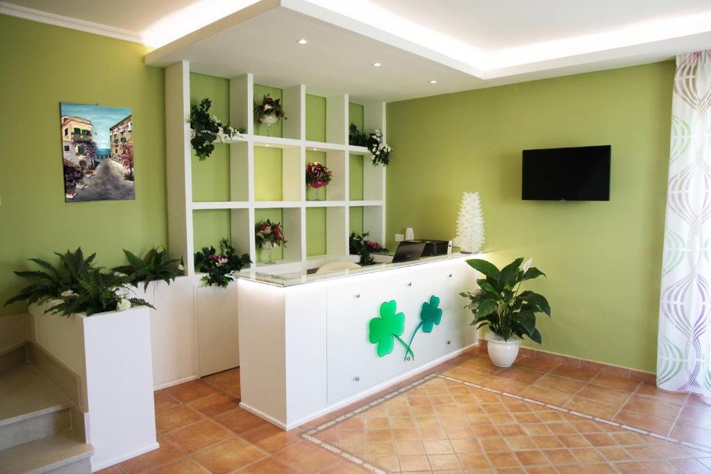 una oficina con paredes verdes y una recepción con plantas en B&B Il Quadrifoglio Tropea, en Tropea