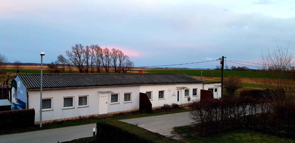 Ein weißes Gebäude mit vielen Fenstern drauf. in der Unterkunft Apartment Ummanz 1 in Lieschow