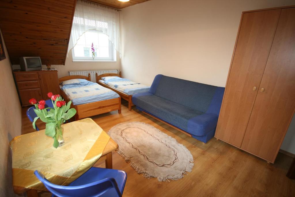 uma sala de estar com um sofá azul e uma mesa em Pokoje Klaudia em Darłowo