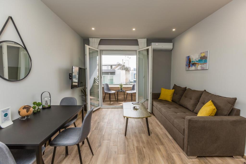 uma sala de estar com um sofá e uma mesa em Raise Athens Metro Apartments em Atenas