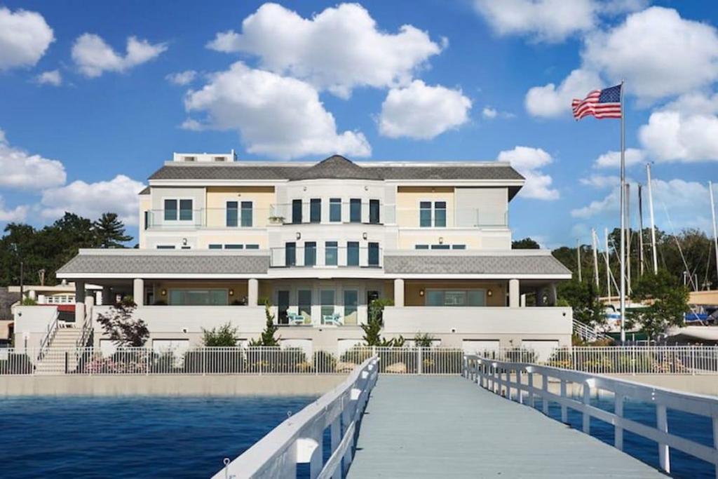 a large white building next to the water at Fathoms Hotel & Marina in Port Washington