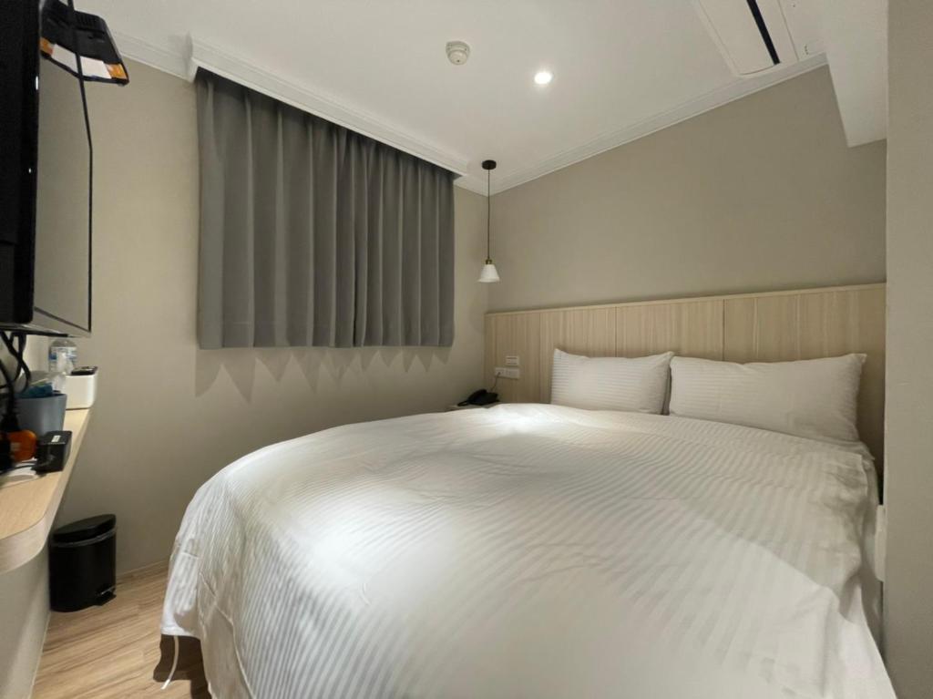Postel nebo postele na pokoji v ubytování Yoshi Hotel - Tainan Station Branch