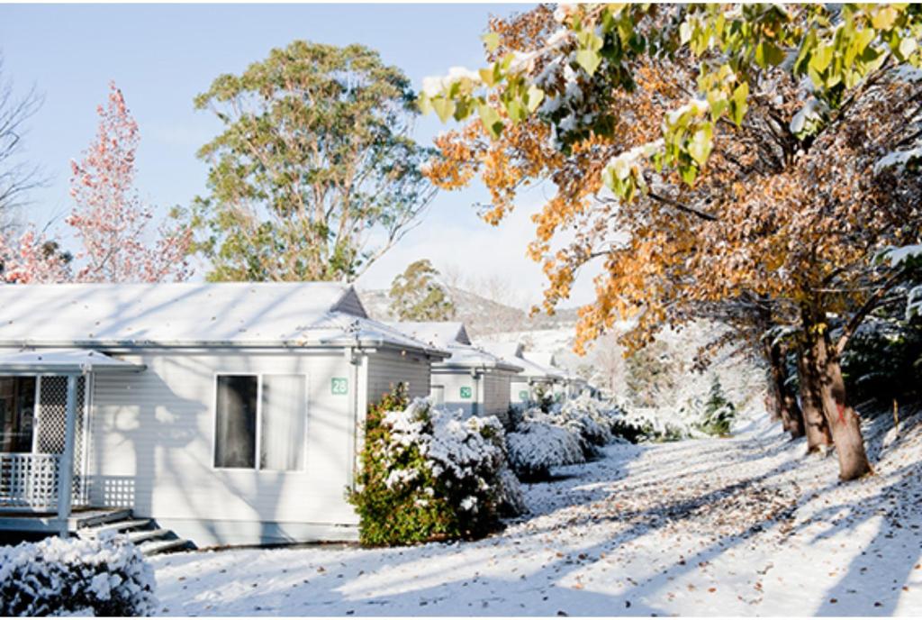 a house with snow on the ground in front of it at Discovery Parks - Jindabyne in Jindabyne