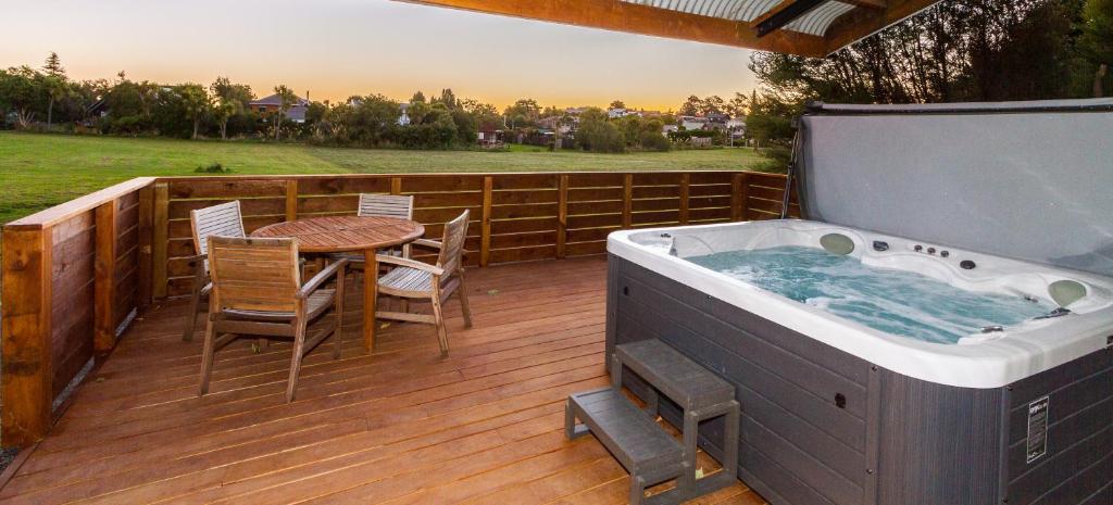 a hot tub on a deck with a table and chairs at The Station - Ohakune Holiday Home in Ohakune