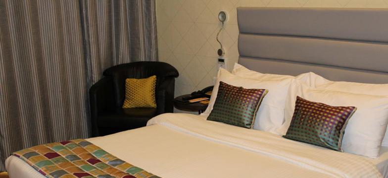 a bed with a white comforter and pillows at Keys Select by Lemon Tree Hotels, Hosur Road, Bengaluru in Bangalore