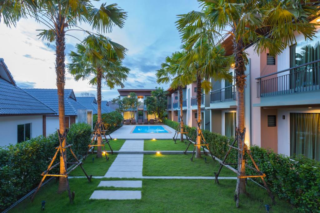 una imagen de un patio trasero con columpio y palmeras en Parida Resort en Bang Tao Beach