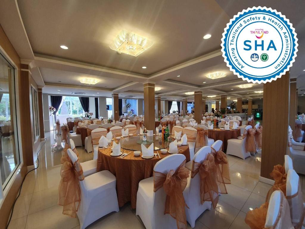 A large banquet room is dressed for a formal meal, with round tables and bow-backed chairs.