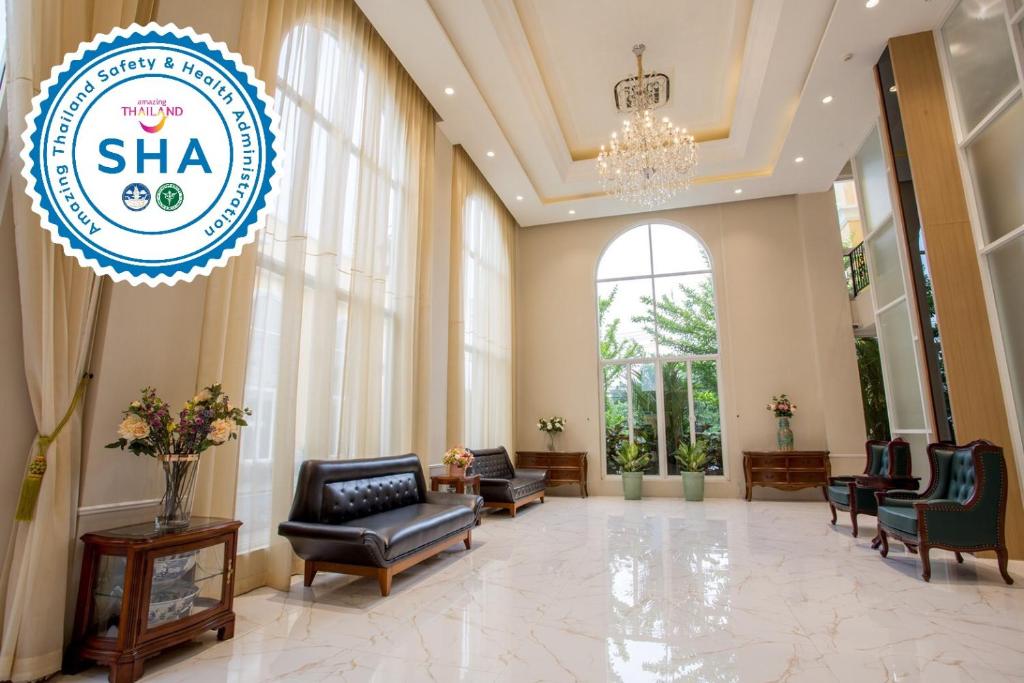 A bright, formal lobby with sofas, armchairs and a tall arched window.