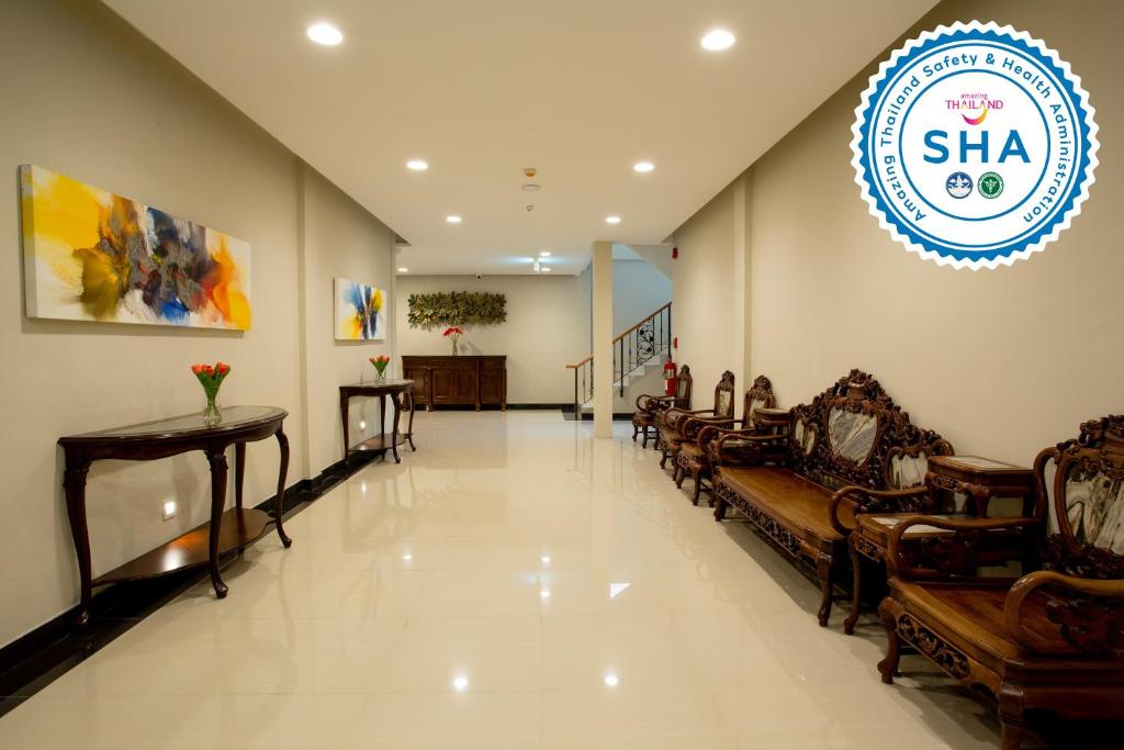 A long lobby corridor lined with ornate wooden seating and console tables.