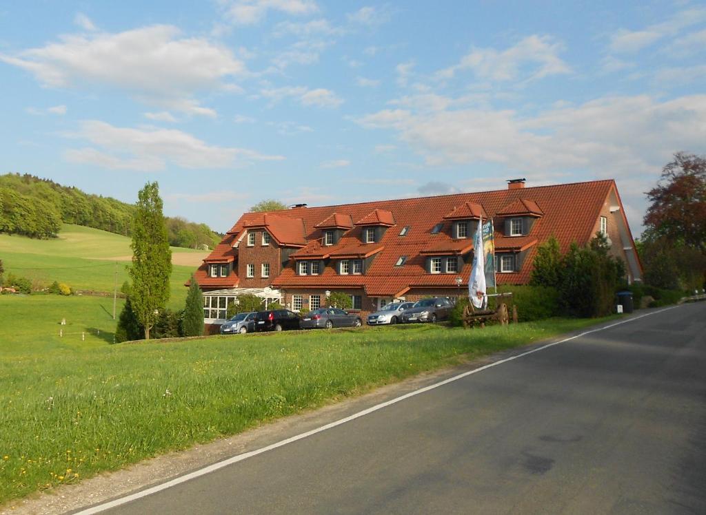 a large house on the side of a road at Hotel Rehkitz in Halle Westfalen