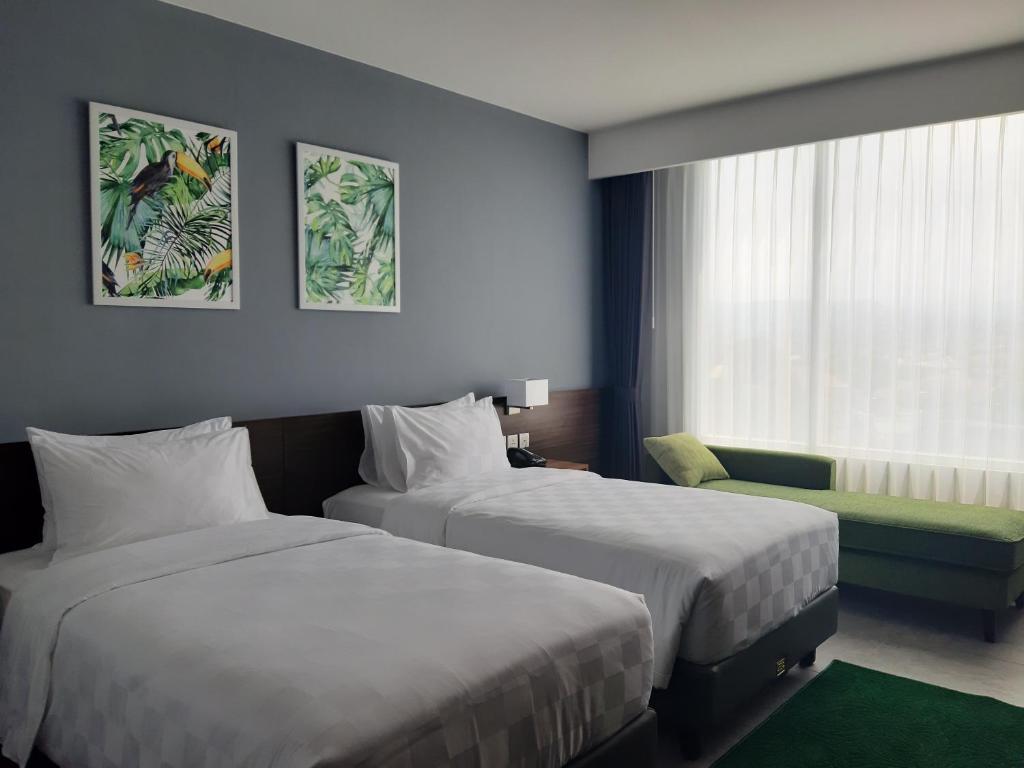 Postel nebo postele na pokoji v ubytování Swiss-Belinn Bogor