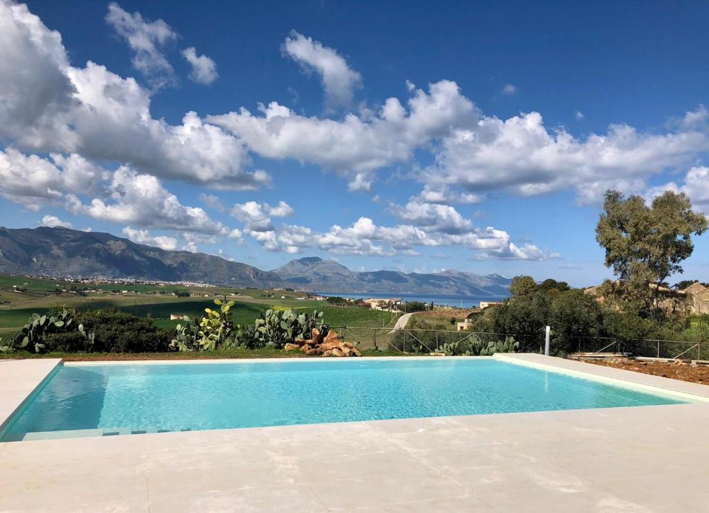 a swimming pool with a view of the mountains at Case Playa Resort Balestrate in Balestrate