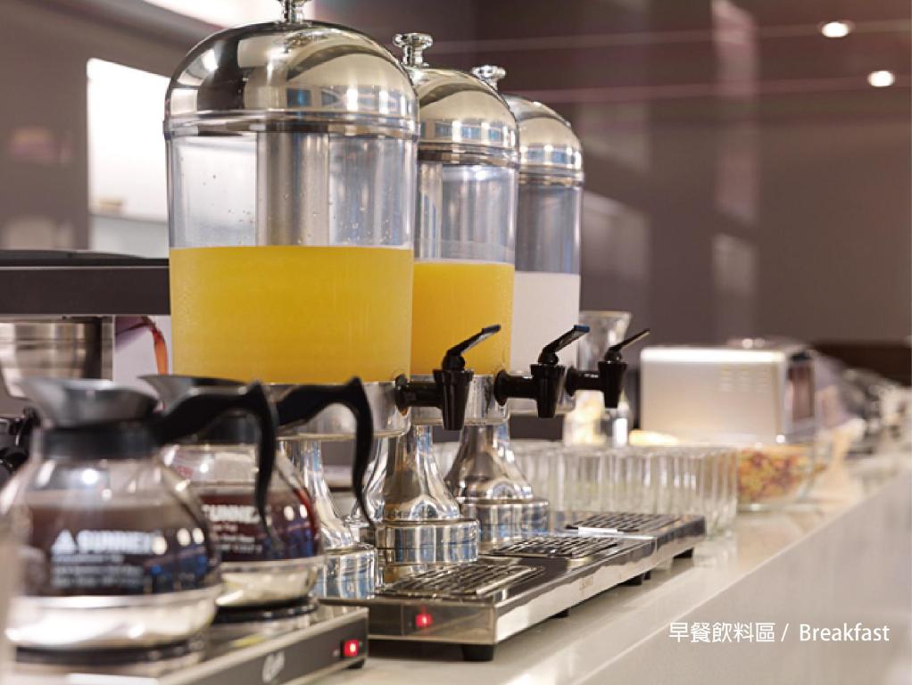 a counter with two glasses of orange juice in jars at Dandy Hotel - Tianmu Branch in Taipei