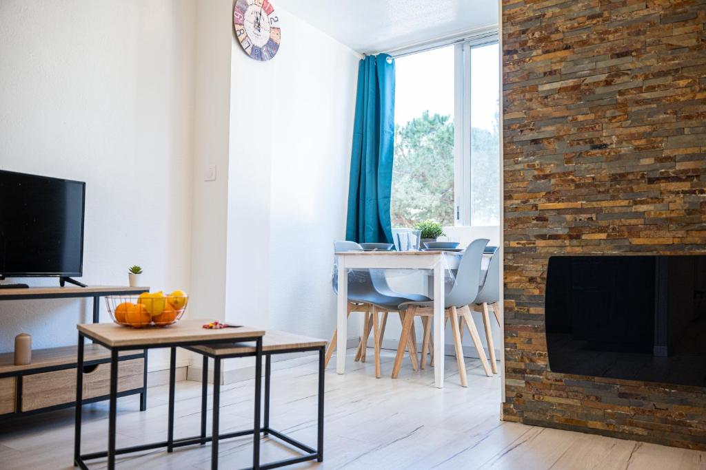 un salon avec une cheminée et une table avec des oranges sur une table dans l'établissement Le Cosy Babylone, à La Grande Motte