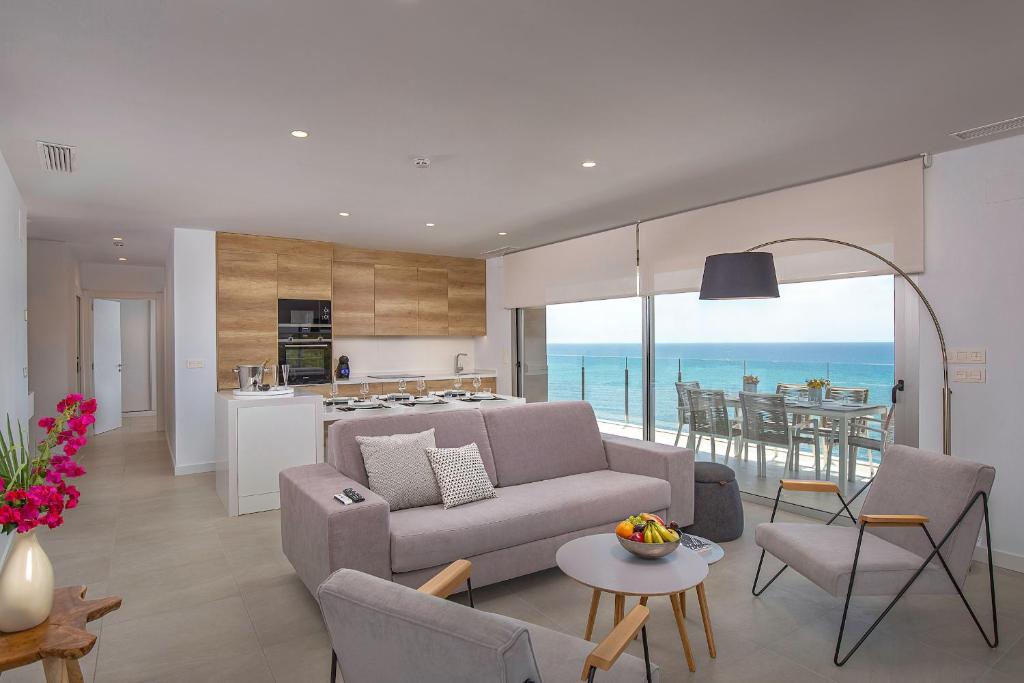 a living room with a couch and a kitchen at Blue Line Apartment Hotel in Villajoyosa
