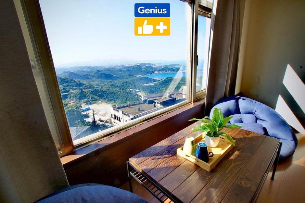 a room with a table and a large window at Old Street Seaview Homestay in Jiufen