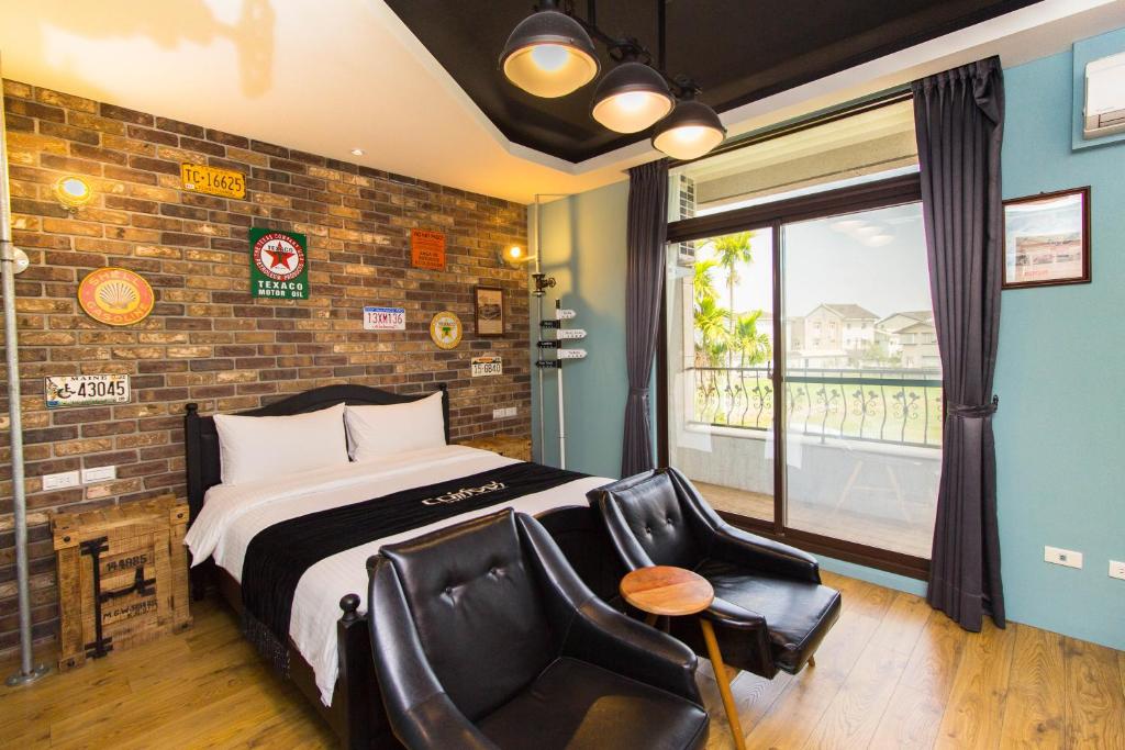 um quarto com uma cama, uma cadeira e uma janela em 田田圈 em Luodong
