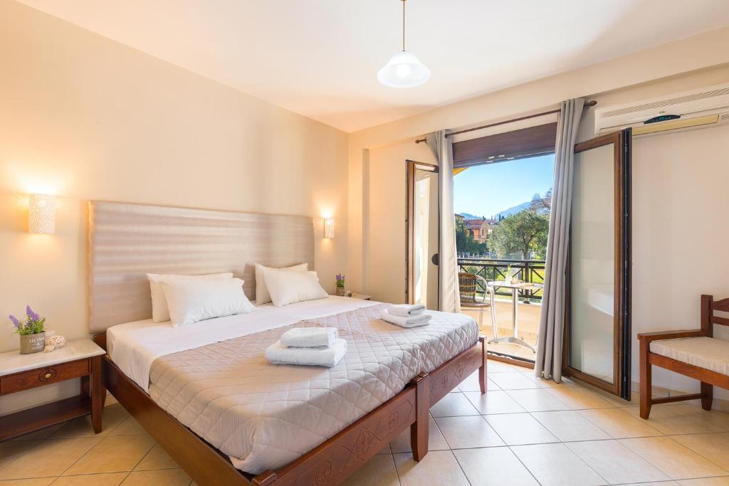 a bedroom with a large bed with a balcony at Lemon Tree Corfu Apartments by Konnect in Ýpsos