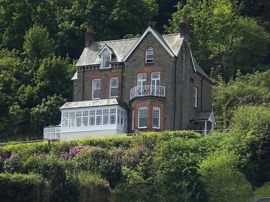 ein großes Backsteinhaus auf einem Hügel in der Unterkunft Highcliffe House in Lynton