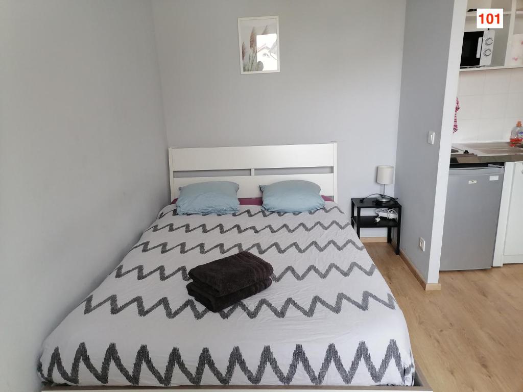 Un dormitorio con una cama con una bolsa negra. en Immoappart, en Albi