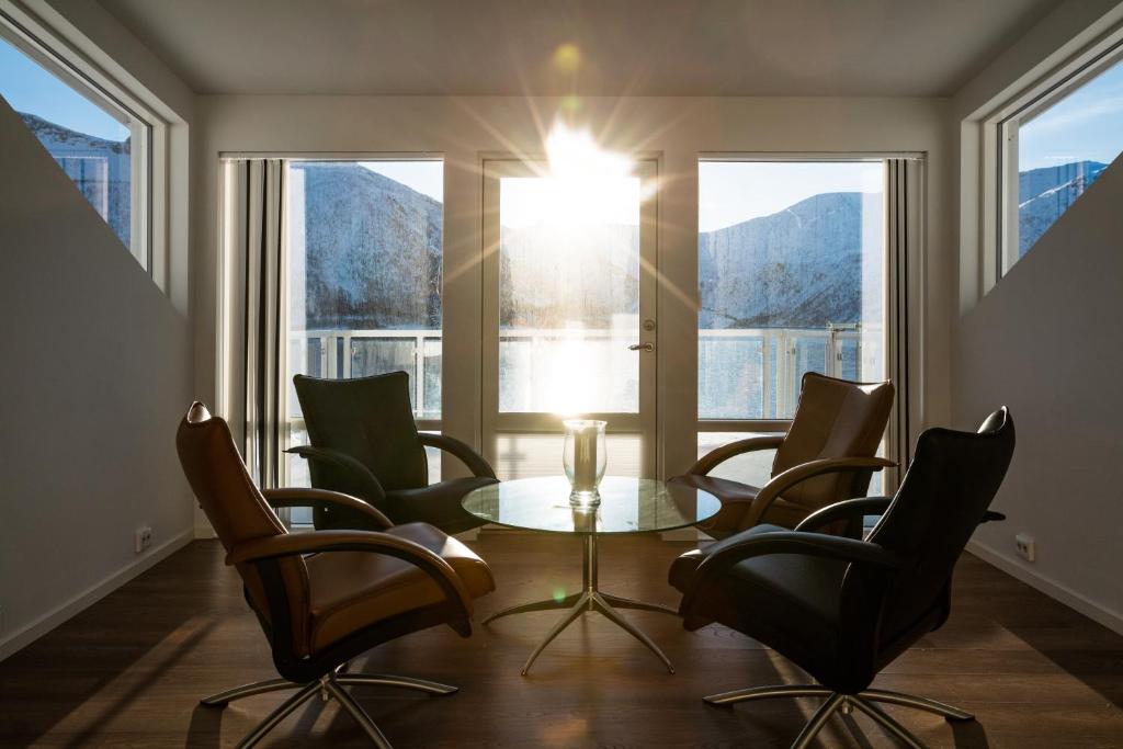 a room with a table and chairs and windows at Penthouse Leilighet TorskenSenteret in Torsken