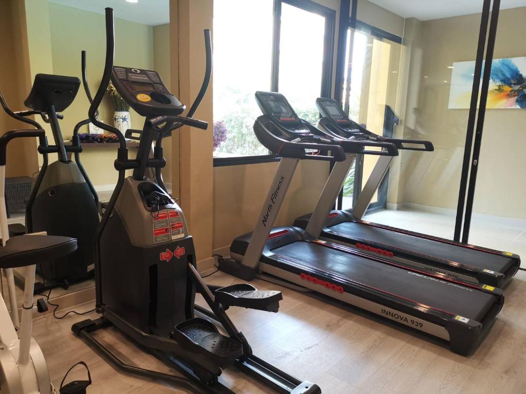 A bright cardio area with two treadmills and two elliptical-style machines.