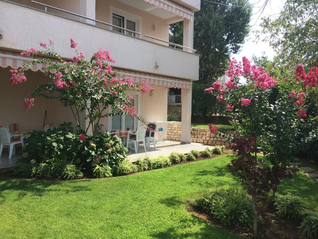 a house with pink flowers in the yard at Apartments Malinska - apartment 1 in Malinska