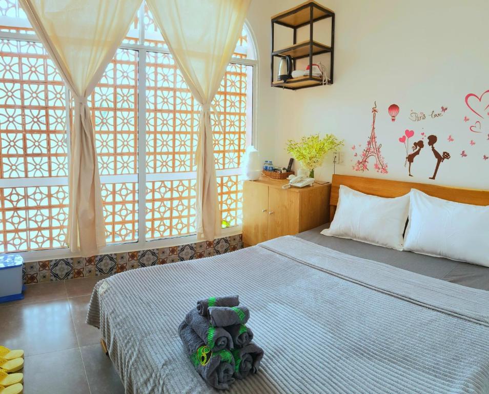 a bedroom with a large bed and large windows at Mekong 69 Hostel - Cạnh Bến Ninh Kiều in Can Tho