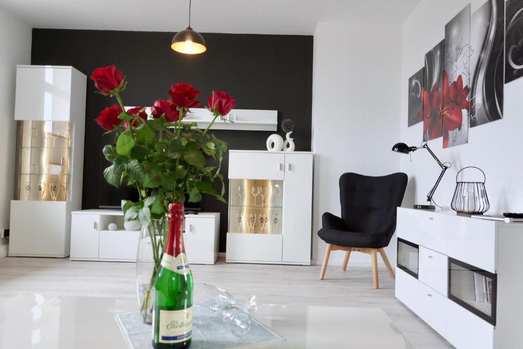 een kamer met een tafel met een vaas van rode rozen bij Ferienwohnung Ostard 1 in Thale