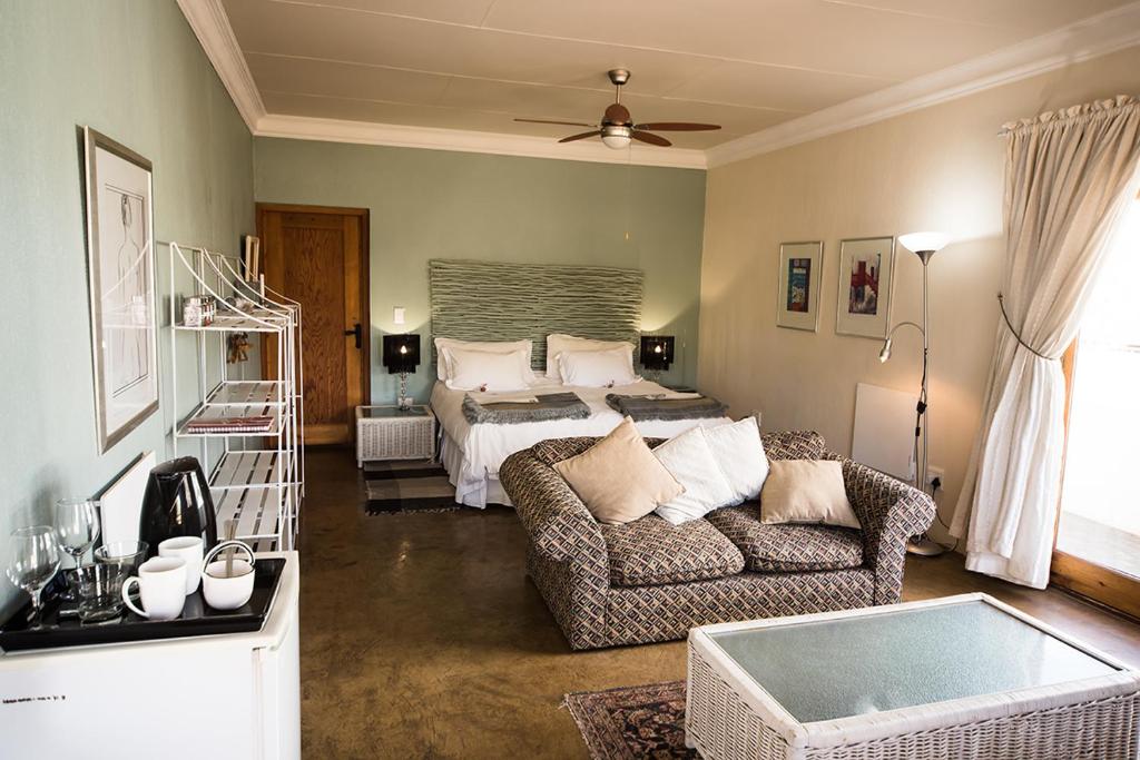 sala de estar con cama y sofá en 278 on Main, en Clarens