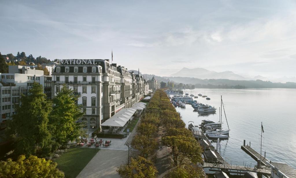 boats are docked at a dock near the water at Grand Hotel National Luzern in Lucerne