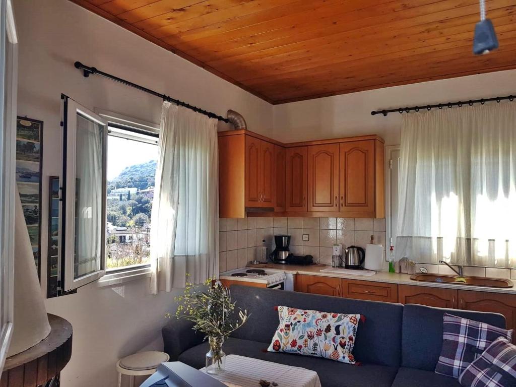 un salon avec un canapé bleu dans une cuisine dans l'établissement Amazing Sea View-Neos Pyrgos Beach -Evoia Greece, à Neos Pirgos
